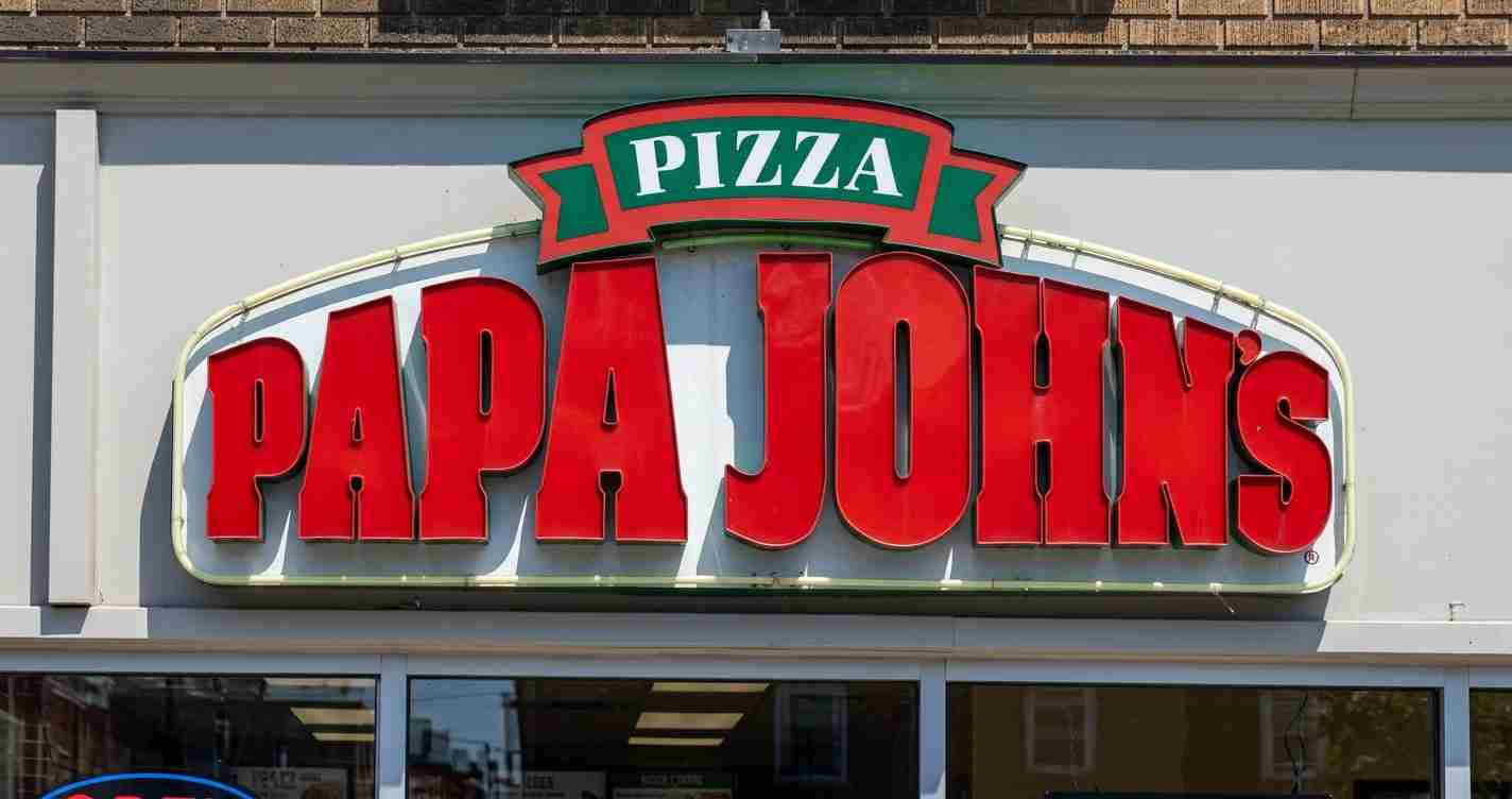 Papa John’s pizza restaurant sign with large red lettering and a green pizza banner at the top.