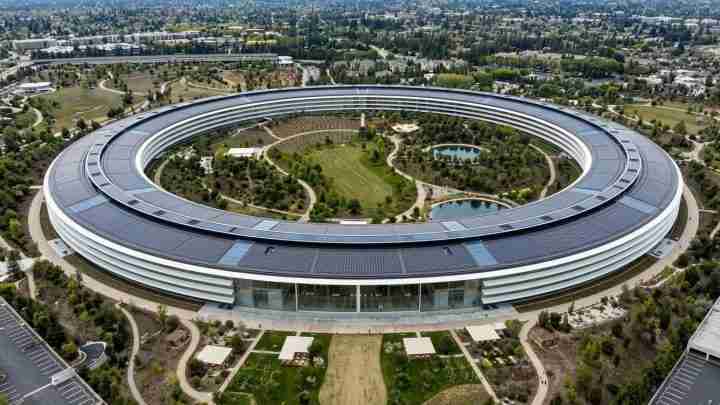 Aerial view of a large circular office complex with a landscaped inner park and ponds, seen from above.