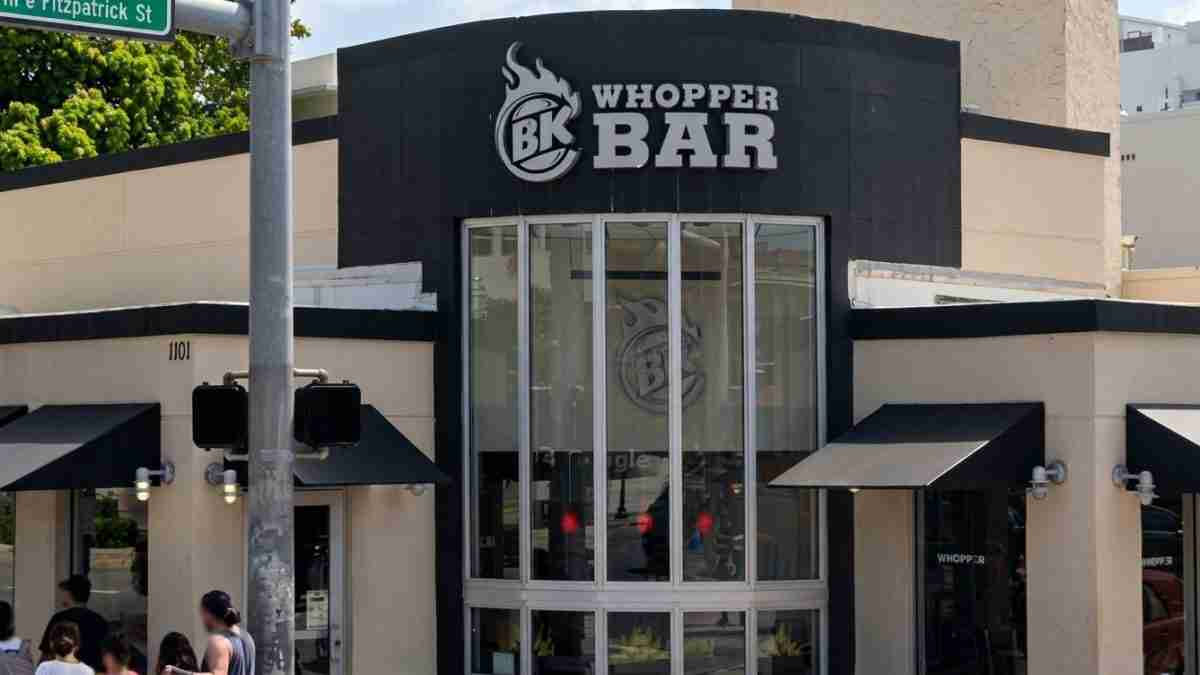 Whopper Bar storefront with a curved glass entrance and bold BK Whopper Bar sign above the doorway on a sunny day