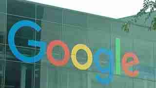 Google logo displayed across a modern glass building façade with colorful letters on the exterior wall