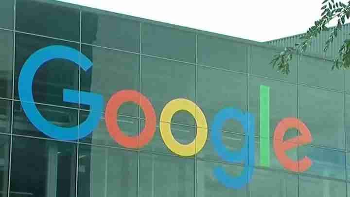 Google logo displayed across a modern glass building façade with colorful letters on the exterior wall