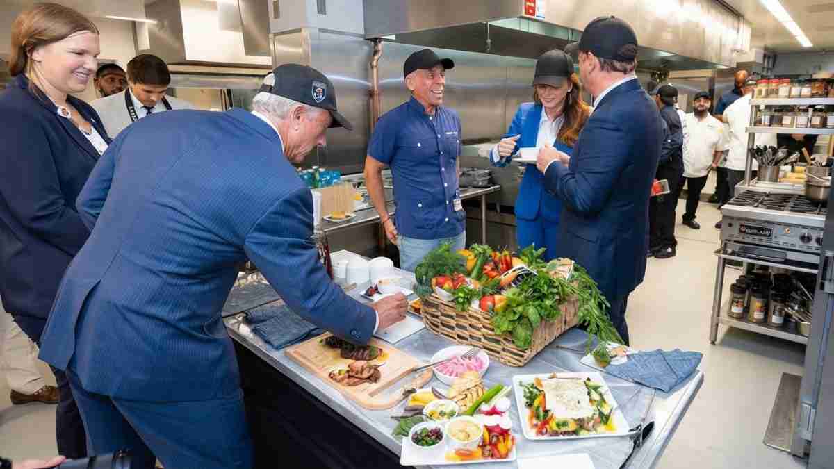 Executives in a commercial kitchen tasting plated dishes laid out on a prep table.