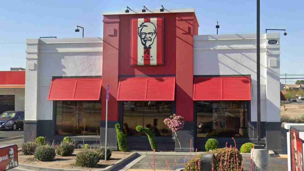 KFC restaurant exterior with red and white facade, red awnings, and Colonel Sanders logo on the sign above the entrance.