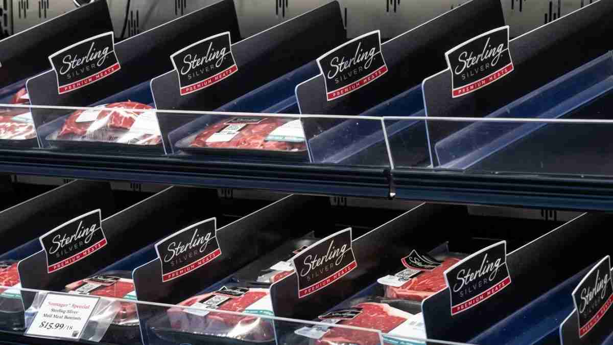Refrigerated display case with multiple bins of Sterling Silver Premium Meats and price tags.