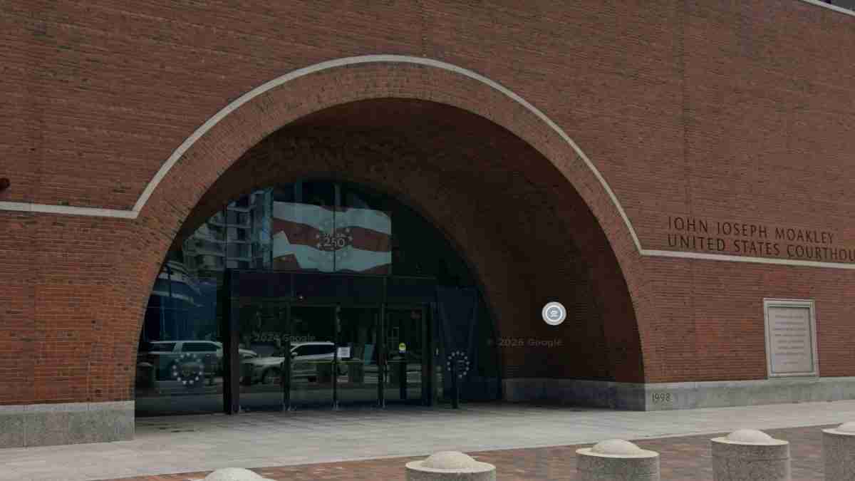 John Joseph Moakley United States Courthouse brick arch entrance with glass doors and a paved plaza in front.