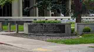 Stone sign for the James A. McClure Federal Building and United States Courthouse at 550 West Fort Street, with greenery around it.