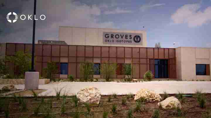 Exterior view of the Groves OKLO Isotopes building with the OKLO logo in the foreground, desert landscaping in front.